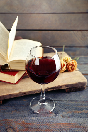 Beautiful composition with glass of wine with old books on table close upの写真素材
