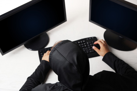 Hacker with computers in roomの写真素材