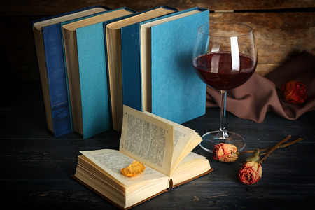 Beautiful composition with glass of wine with old books on table close upの写真素材