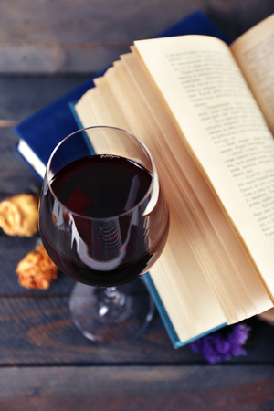 Beautiful composition with glass of wine with old books on table close upの写真素材