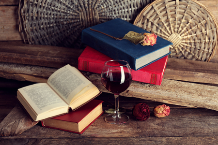 Beautiful composition with glass of wine with old books on table close upの写真素材