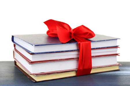 Stack of books with ribbon on table isolated on whiteの写真素材