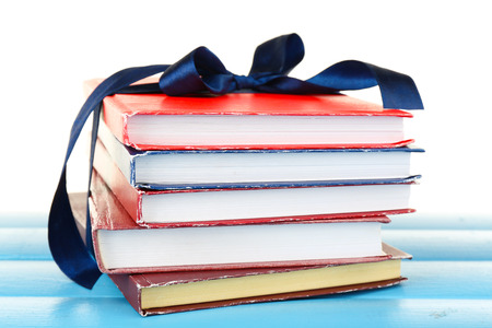 Stack of books with ribbon on light backgroundの写真素材
