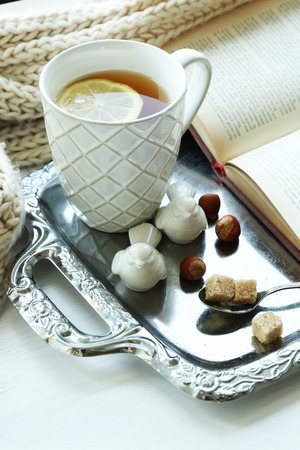 Cup of tea with book on metal tray, closeupの写真素材