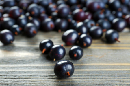 Heap of wild black currant on wooden table close upの写真素材
