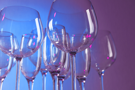 Empty wine glasses on color backgroundの写真素材