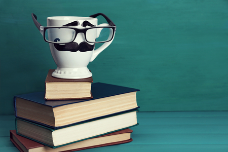 Books and cup with mustache on colorful backgroundの写真素材