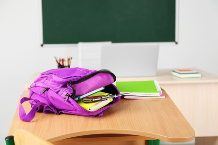 Backpack with knife in classroom, close up. Juvenile delinquencyの写真素材
