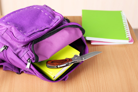 Backpack with knife in classroom, close up. Juvenile delinquencyの写真素材
