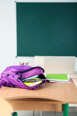 Backpack with knife in classroom, close up. Juvenile delinquencyの写真素材