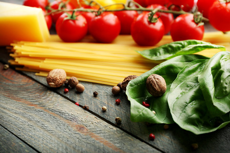 Pasta spaghetti with tomatoes, cheese and basil on rustic wooden  backgroundの写真素材