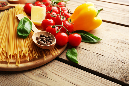 Pasta spaghetti with tomatoes, cheese and basil on rustic wooden  backgroundの写真素材