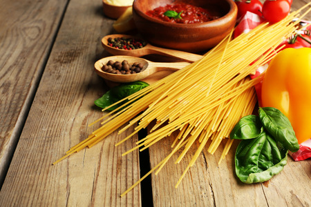 Pasta spaghetti with tomatoes, sauce bolognese, cheese and basil on rustic wooden  backgroundの写真素材