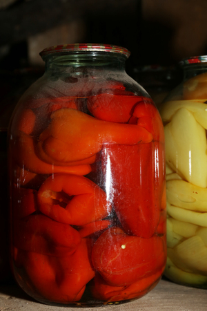 Home preserved peppers in glass jars in cellar, closeupの写真素材