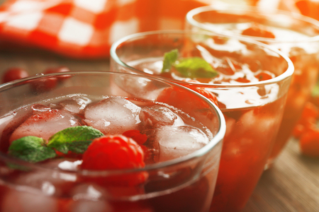 Glasses of berry juice on wooden table, closeupの写真素材