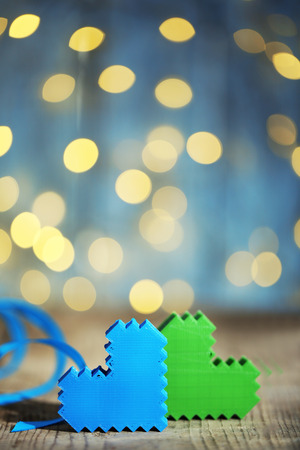 Hearts on wooden table and blurred background with lightsの写真素材