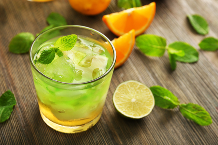 Glass of lime juice with orange on wooden backgroundの写真素材