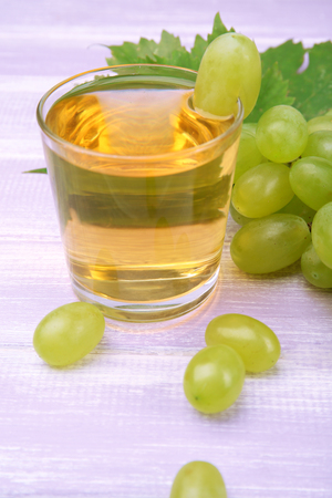 Glass of grape juice on wooden table, closeupの写真素材