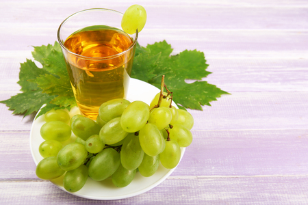 Glass of grape juice on wooden backgroundの写真素材