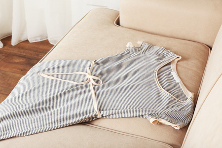 Female dress on sofa in roomの写真素材