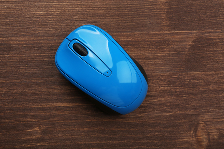 Wireless computer mouse on wooden backgroundの写真素材