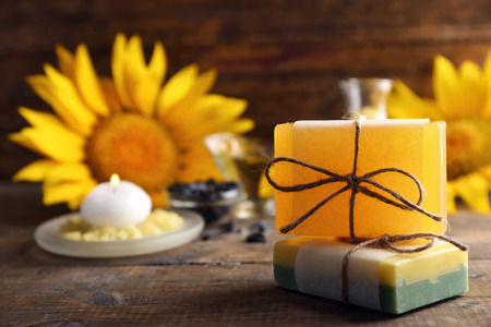 Soap bar and Spa treatments and sunflower on wooden background