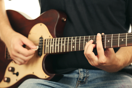 Young musician playing electric guitar close upの写真素材