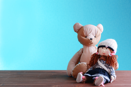 Doll and teddy bear on blue backgroundの写真素材