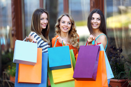Beautiful young women with shopping bags on city streetの写真素材