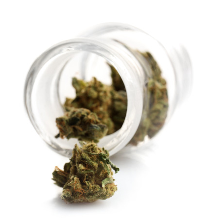 Dry medical cannabis in jar isolated on whiteの写真素材