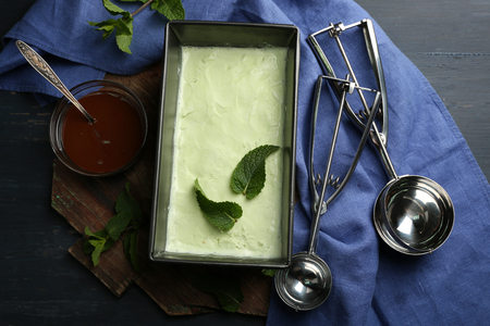 Homemade ice cream in frozen metallic container on dark wooden backgroundの写真素材