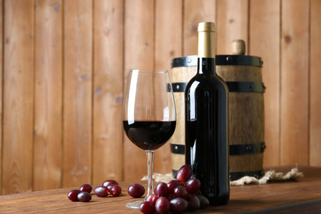 Beautiful still life with wine and grape on wooden tableの写真素材