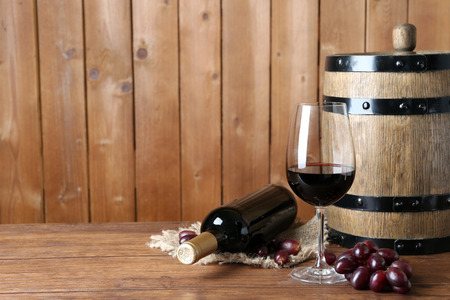Beautiful still life with wine and grape on wooden tableの写真素材