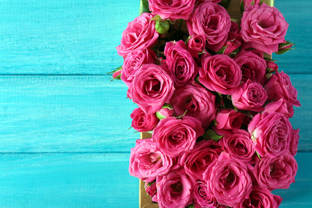 Beautiful roses in box on wooden backgroundの写真素材