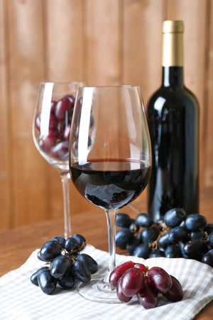 Beautiful still life with wine and grape on wooden tableの写真素材