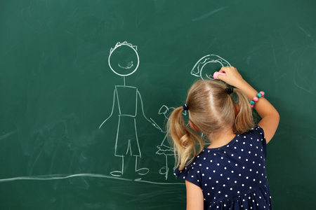 Girl drawing on blackboard, close-upの写真素材