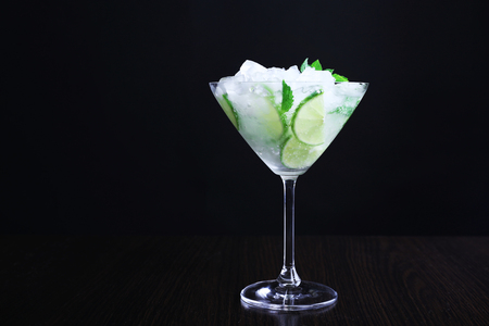 Glass of cocktail with ice on dark backgroundの写真素材