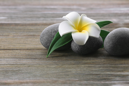 Spa stones with flower on wooden backgroundの写真素材