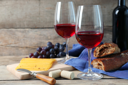 Still life of wine, grape, cheese and bread on rustic wooden backgroundの写真素材