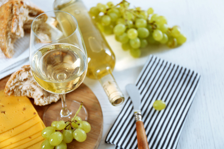Still life of wine, grape, cheese and bread on light backgroundの写真素材