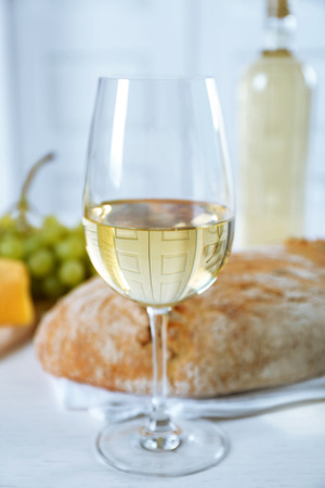 Still life of wine, grape, cheese and bread on light backgroundの写真素材