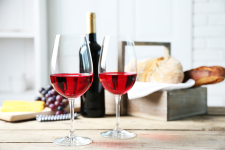 Still life of wine, grape, cheese and bread on light backgroundの写真素材