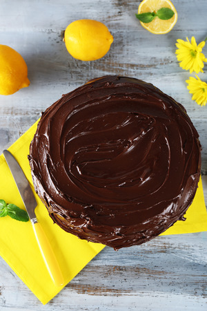 delicious chocolate cake near lemons on grey wooden tableの写真素材