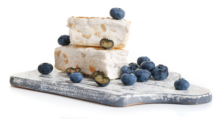 Sweet nougat with hazelnuts and blueberries isolated on whiteの写真素材