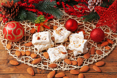 Sweet nougat with almonds and Christmas decoration table close upの写真素材
