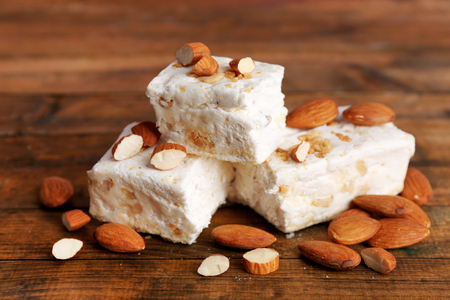Sweet nougat with almonds on wooden backgroundの写真素材