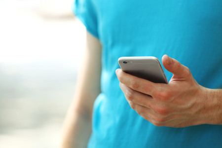 Man holding smart mobile phone outdoors