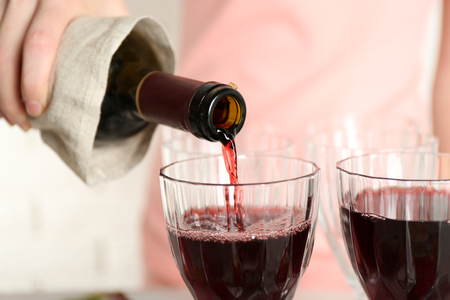 Woman pouring wine into glass, close upの写真素材