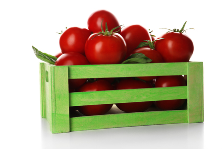 Red tomatoes in green wooden box isolated on whiteの写真素材