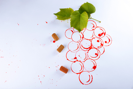 Grapes painted with red wine and cork isolated on whiteの写真素材